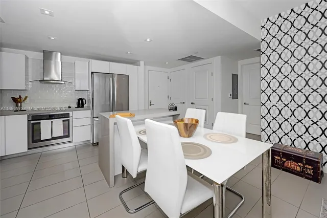 a white kitchen with a sink a stove a refrigerator and cabinets