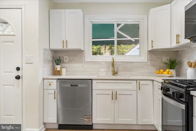 a kitchen with white cabinets and a window