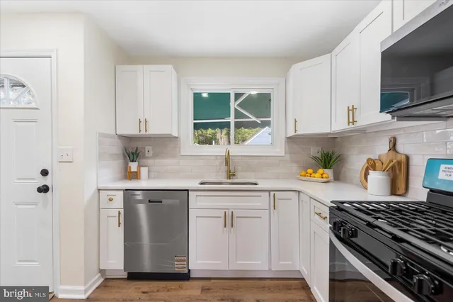 a kitchen with stainless steel appliances granite countertop a sink stove and cabinets