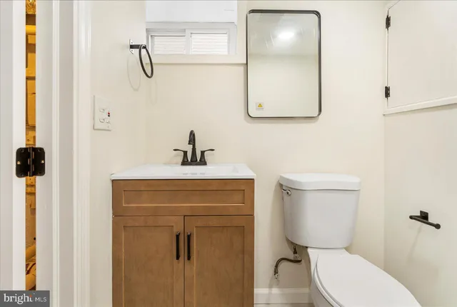 a bathroom with a toilet a sink and mirror