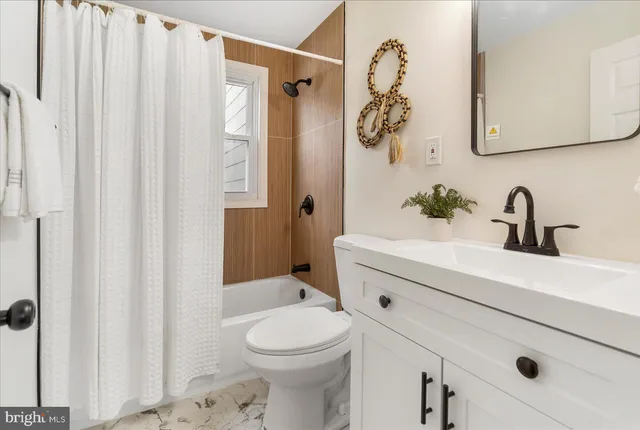 a bathroom with a sink a toilet and shower curtain