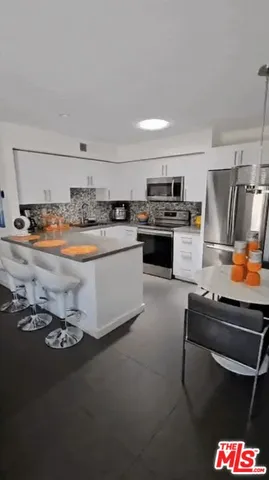 a kitchen with stainless steel appliances a stove a sink and a refrigerator