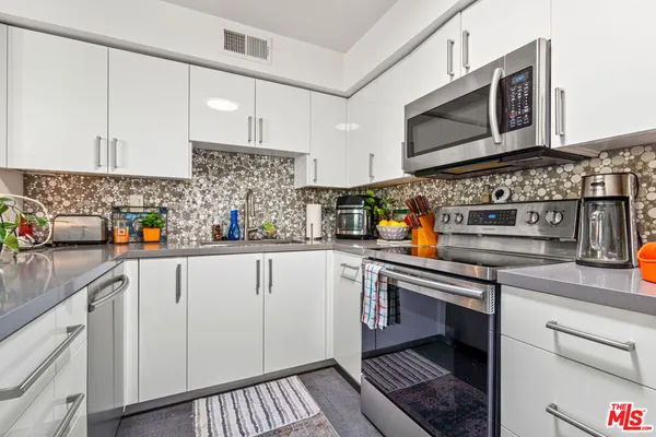 a kitchen with stainless steel appliances granite countertop a sink and cabinets