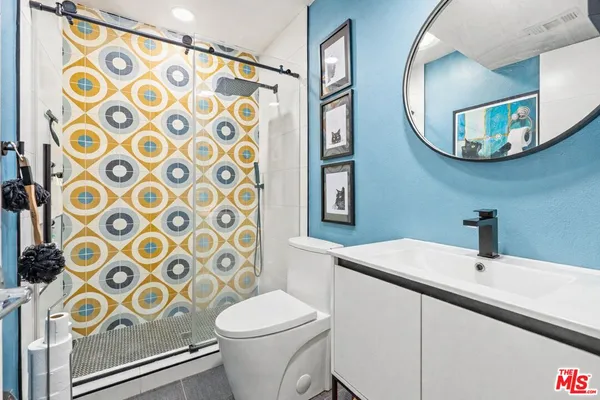 a bathroom with a sink and mirror with toilet