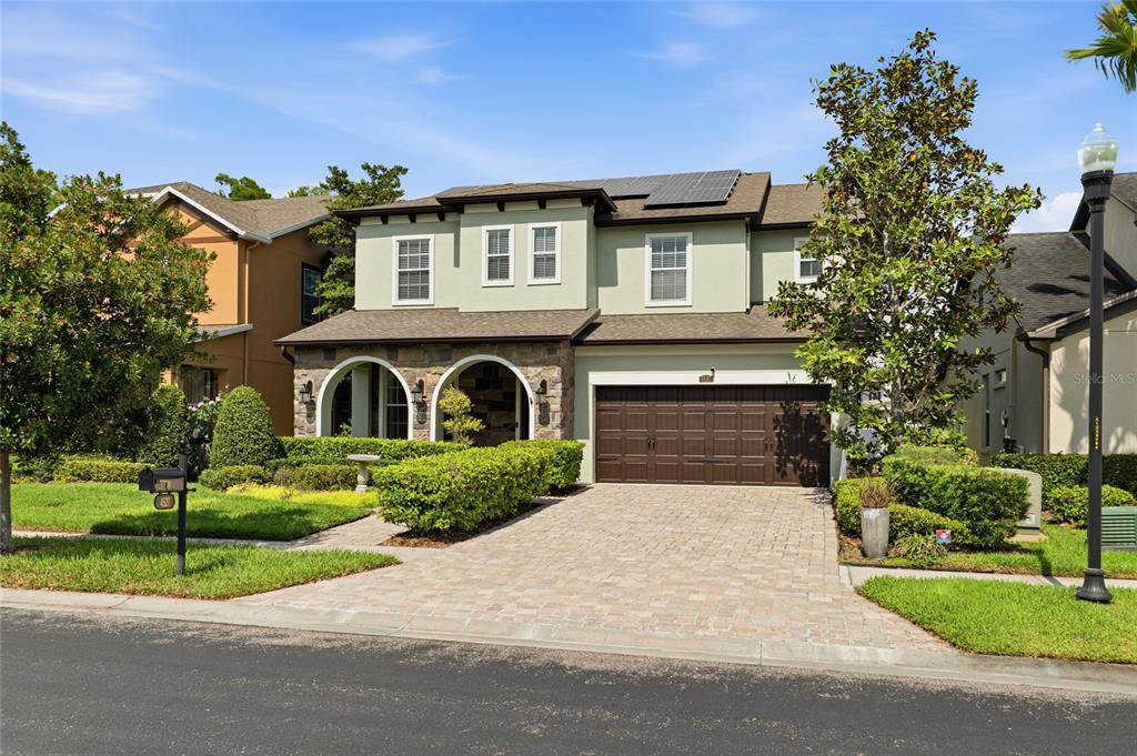 a front view of a house with a garden and trees