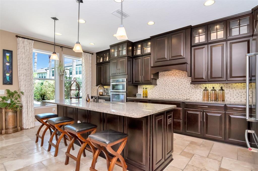 4527 Scarlet Loop Wesley Chapel, FL 33544 - Photo 22 of 57 a kitchen with stainless steel appliances granite countertop a sink a stove and a refrigerator