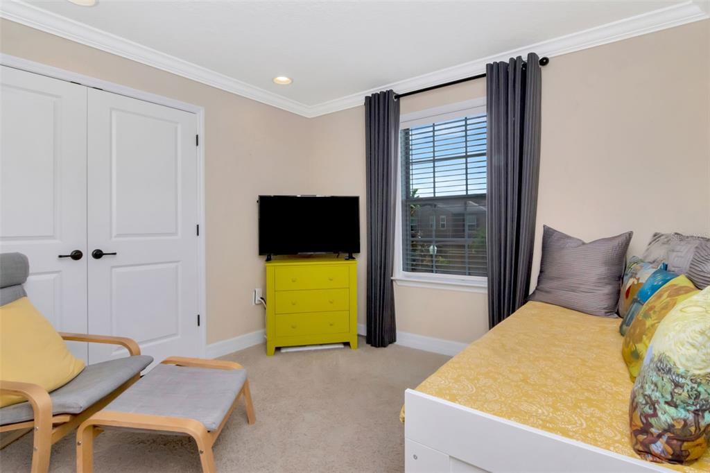 4527 Scarlet Loop Wesley Chapel, FL 33544 - Photo 40 of 57 a bedroom with a bed and a flat screen tv