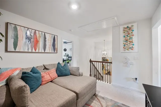 a living room with furniture stairs and a window