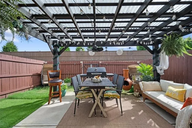 a view of a patio with table and chairs with wooden fence and plants