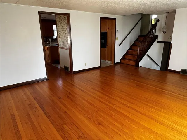 a view of a hallway with wooden floor and stairs