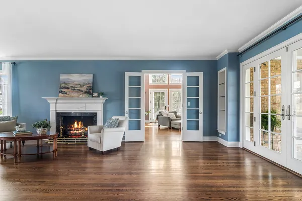 a living room with furniture large windows and wooden floor