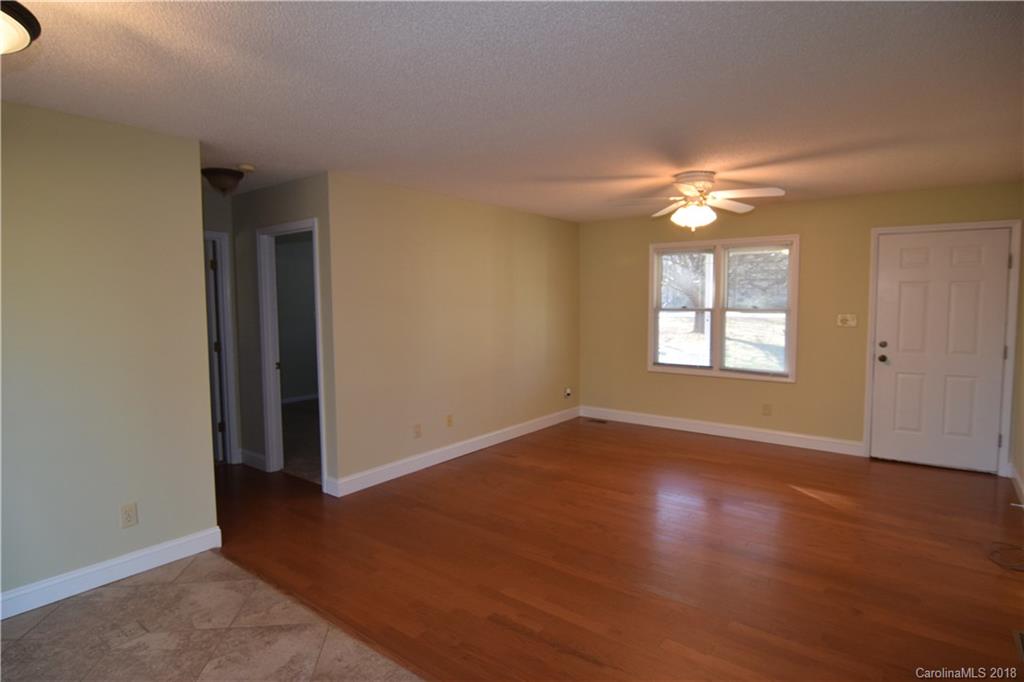 8667 Unity Church Road Denver, NC 28037 - Photo 17 of 23 an empty room with wooden floor chandelier fan and windows