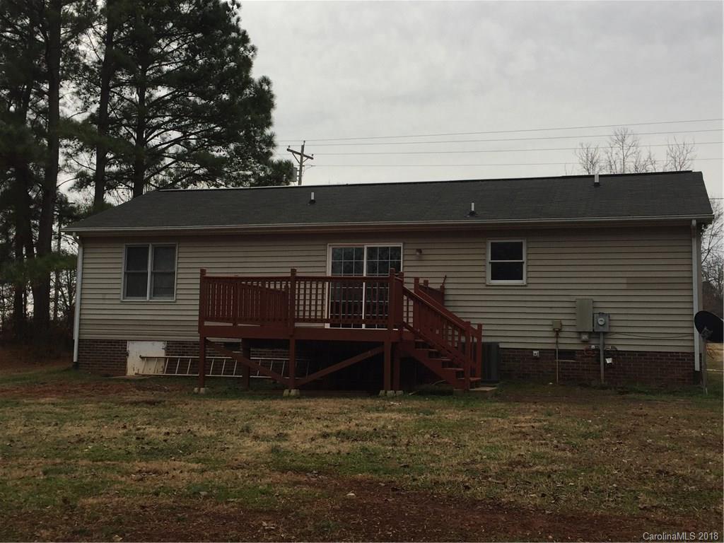 8667 Unity Church Road Denver, NC 28037 - Photo 18 of 23 a backyard of a house with wooden deck and barbeque oven
