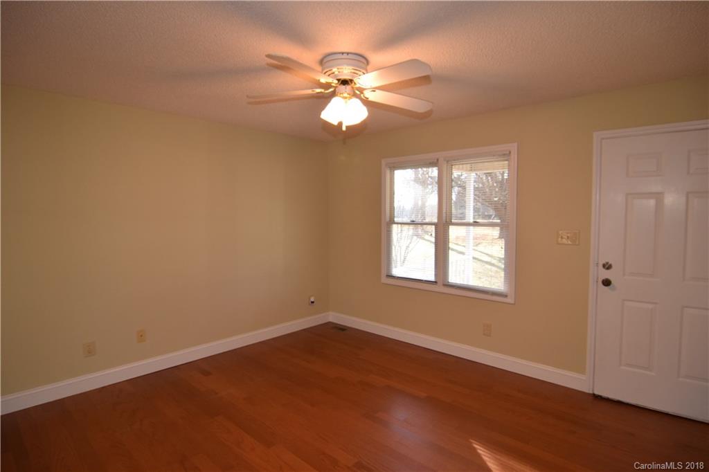 8667 Unity Church Road Denver, NC 28037 - Photo 3 of 23 an empty room with wooden floor fan and windows