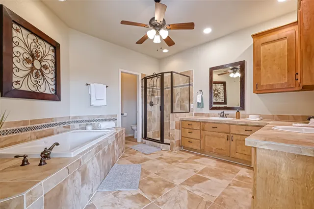 a spacious bathroom with a tub sink and mirror