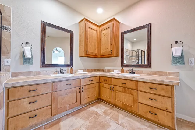 a spacious bathroom with a granite countertop sink and a mirror