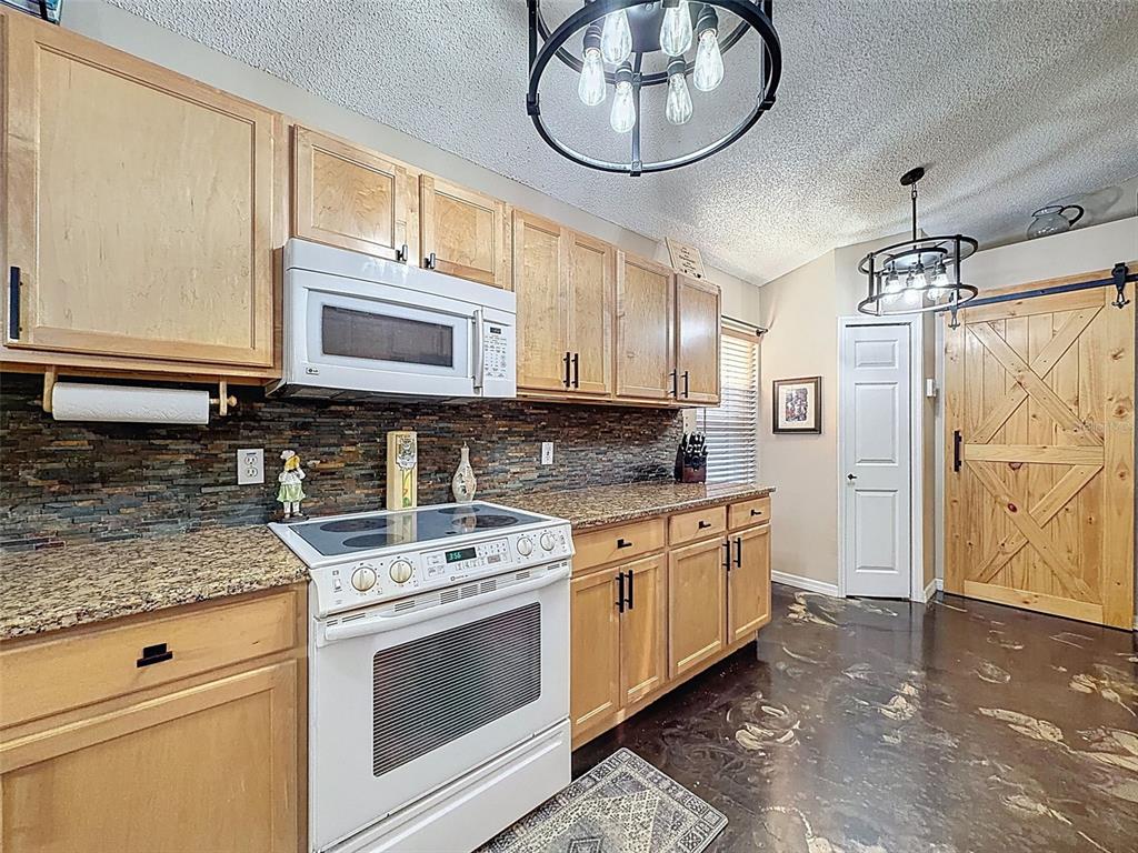 5407 Treig Lane Wesley Chapel, FL 33545 - Photo 15 of 70 a kitchen with stainless steel appliances granite countertop a stove a sink and a microwave