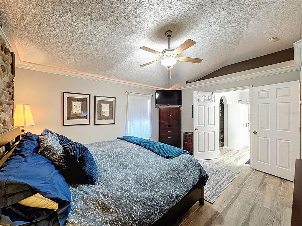 5407 Treig Lane Wesley Chapel, FL 33545 - Photo 26 of 70 a spacious bedroom with a large bed and a chandelier