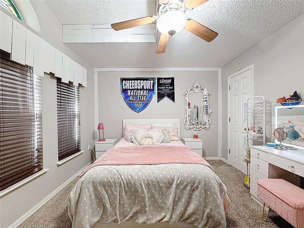 5407 Treig Lane Wesley Chapel, FL 33545 - Photo 32 of 70 a bedroom with a bed and ceiling fan