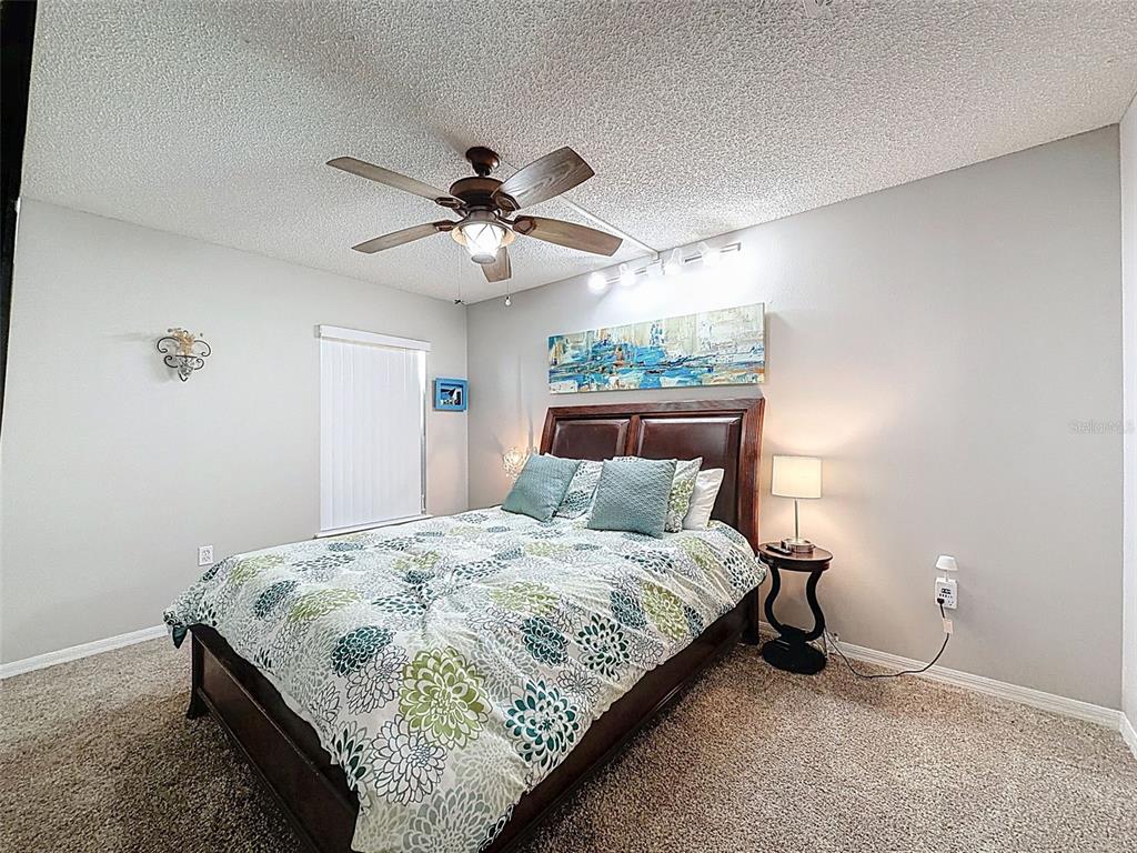 5407 Treig Lane Wesley Chapel, FL 33545 - Photo 35 of 70 a bedroom with a large bed and a chandelier