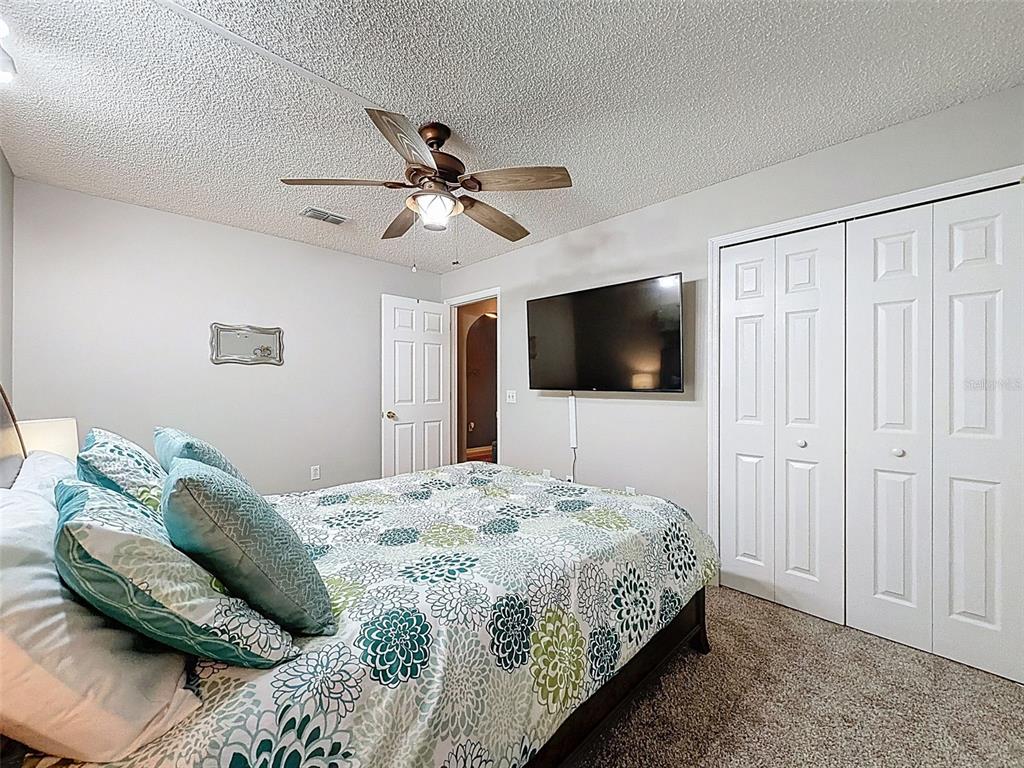 5407 Treig Lane Wesley Chapel, FL 33545 - Photo 36 of 70 a bedroom with a bed a tv and wooden floor