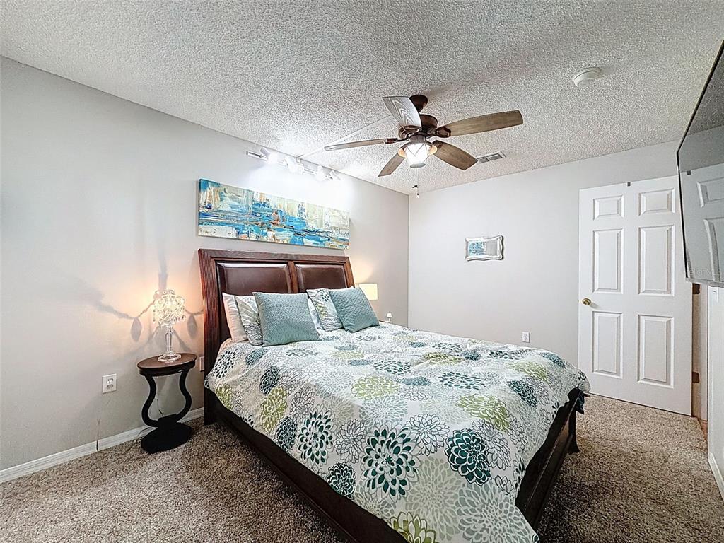 5407 Treig Lane Wesley Chapel, FL 33545 - Photo 37 of 70 a bedroom with a bed and a chandelier