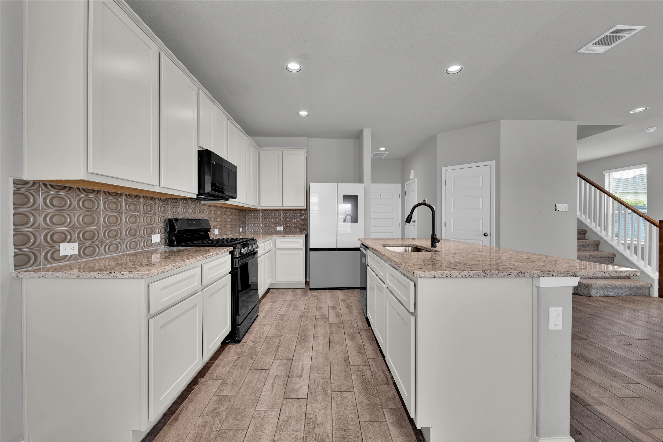 101 Crescent Street Georgetown, TX 78626 - Photo 11 of 39 Kitchen features ample counter space, rich wood flooring, and bright recessed lighting.