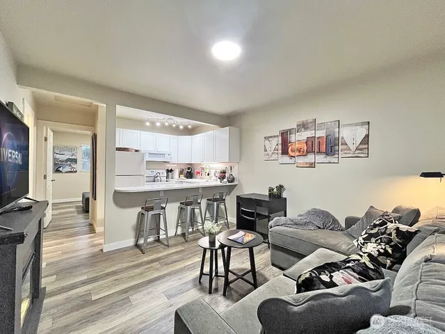 a living room with furniture and a view of kitchen
