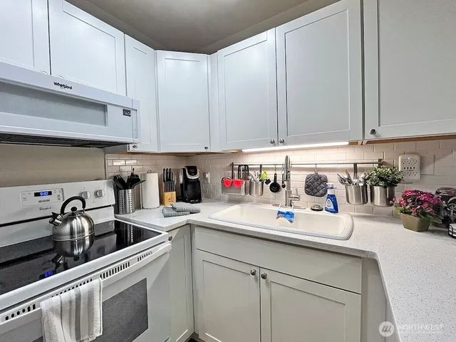 a kitchen with a sink a stove and cabinets
