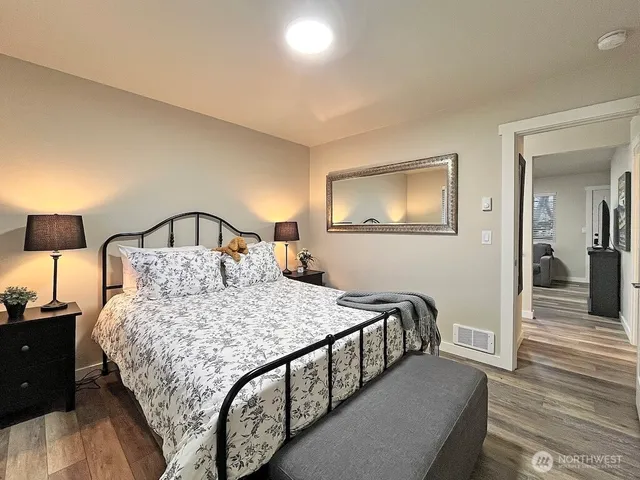 a bedroom with a bed and wooden floor