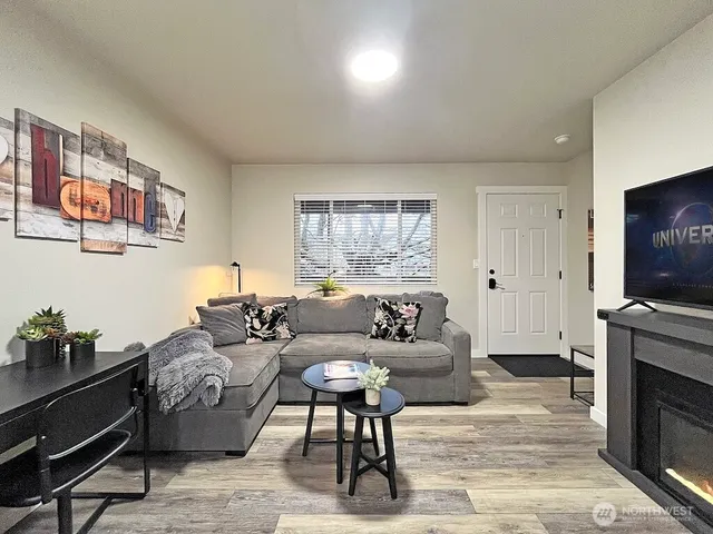 a living room with furniture a flat screen tv and a fireplace