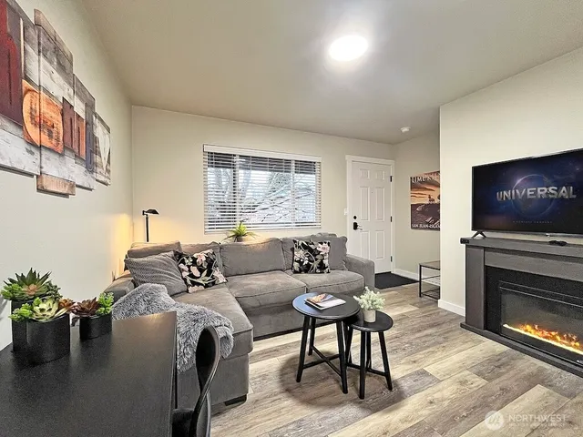 a living room with furniture a flat screen tv and a fireplace