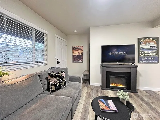 a living room with furniture a flat screen tv and a fireplace