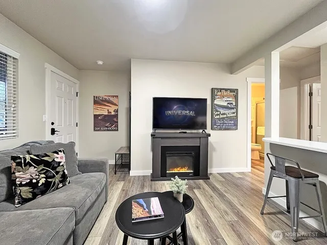 a living room with furniture a flat screen tv and a fireplace