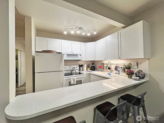 a kitchen with refrigerator and white cabinets