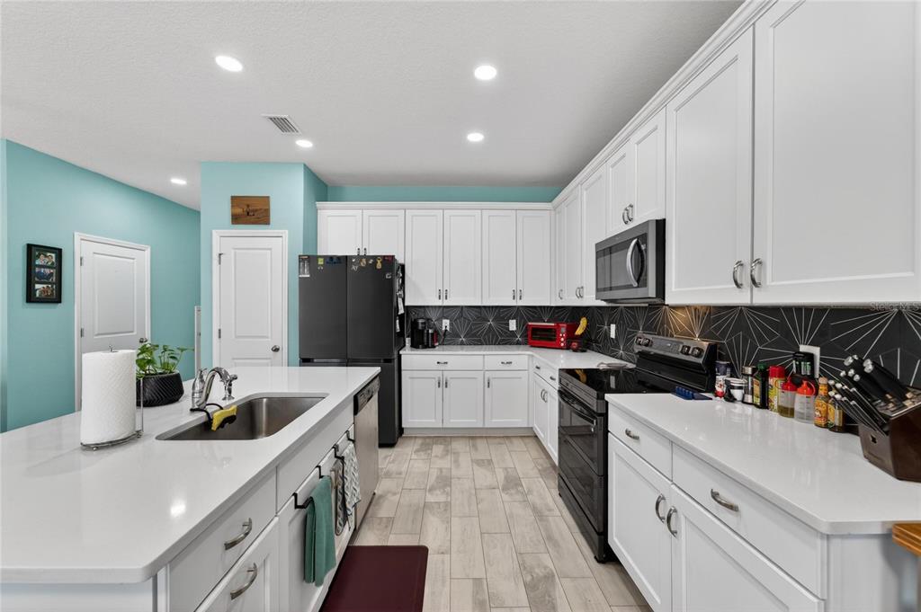 10908 Quickwater Court Riverview, FL 33569 - Photo 12 of 35 a kitchen with a sink stainless steel appliances and white cabinets