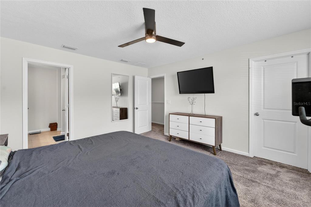 10908 Quickwater Court Riverview, FL 33569 - Photo 19 of 35 a bedroom with a bed and a flat screen tv