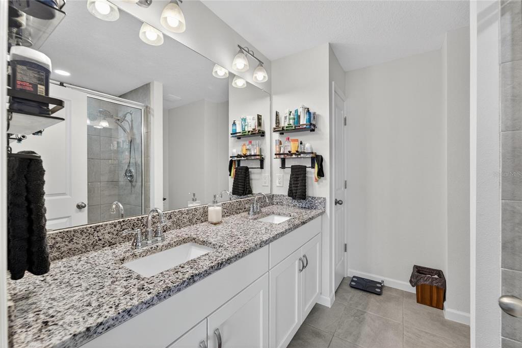10908 Quickwater Court Riverview, FL 33569 - Photo 21 of 35 a bathroom with a sink double vanity granite and a shower