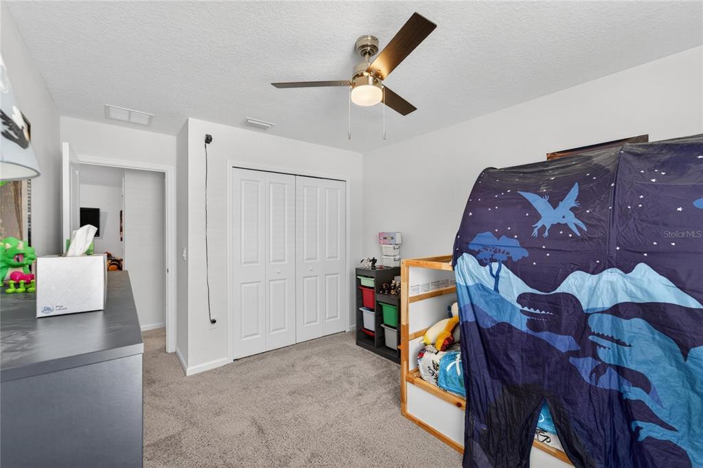 10908 Quickwater Court Riverview, FL 33569 - Photo 25 of 35 a bedroom with a bed and a chandelier