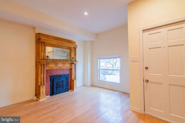 a view of an empty room with a fireplace and a window