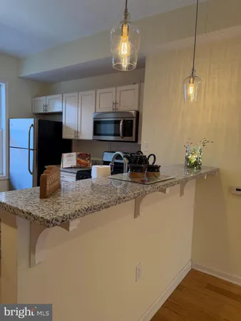a kitchen with stainless steel appliances granite countertop a sink a stove a microwave a refrigerator a sink a refrigerator and microwave