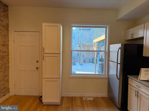a view of kitchen with a refrigerator wooden floor and cabinet