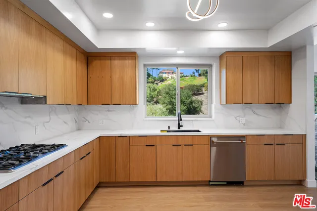 a kitchen with kitchen island granite countertop a sink cabinets and window