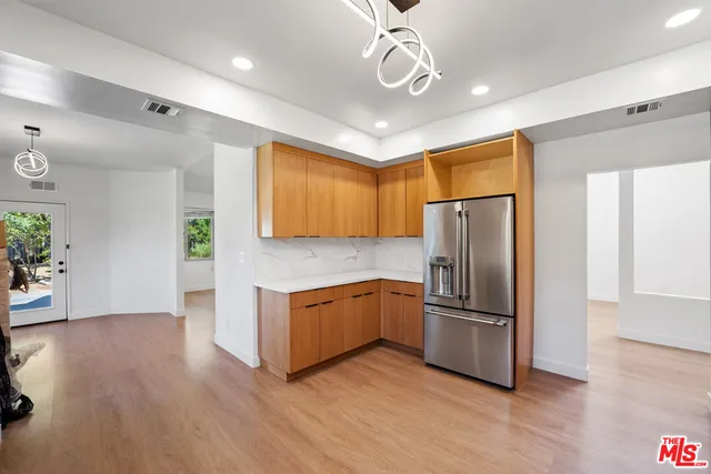 a kitchen with stainless steel appliances granite countertop a refrigerator a stove and a wooden floors