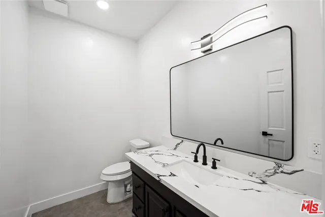 a bathroom with a sink and mirror with toilet