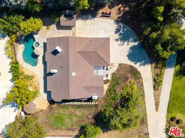 an aerial view of a house with swimming pool and garden