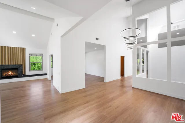 a view of a livingroom with wooden floor a fireplace and window