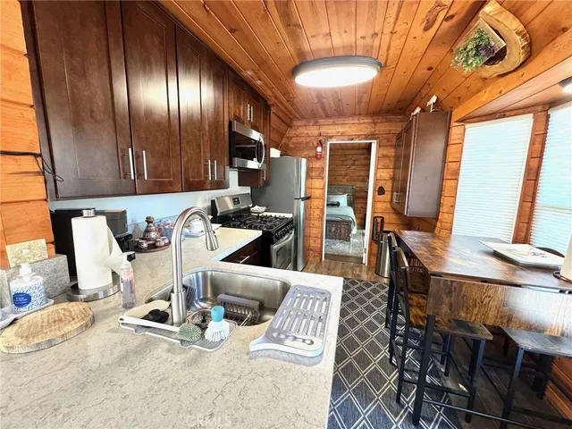 a kitchen with granite countertop a stove a sink and a dining table