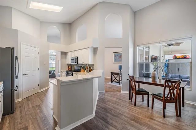 a living room with furniture wooden floor and a kitchen view