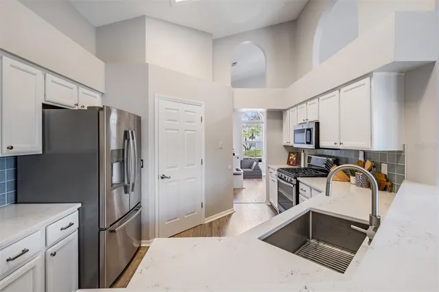 a kitchen with stainless steel appliances granite countertop a refrigerator and a sink